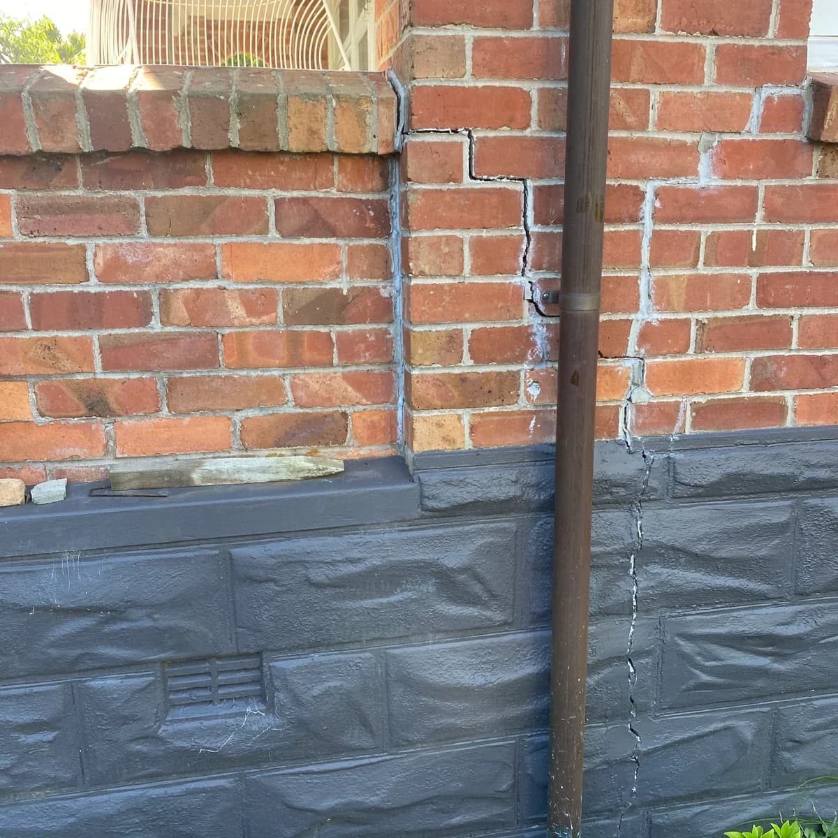 Stepped cracking visible across brickwork